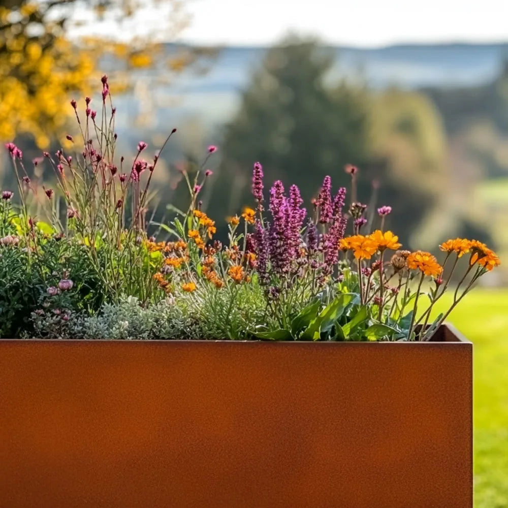 Metal planter box with flowers in a garden setting