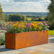 Rusty metal planter with flowers on a patio