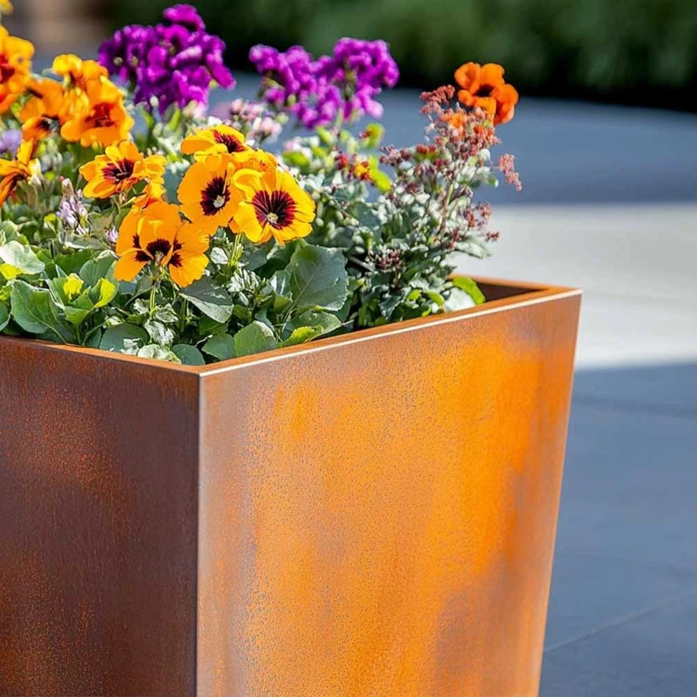 Corten rusted metal planter with colourful flowers outdoors