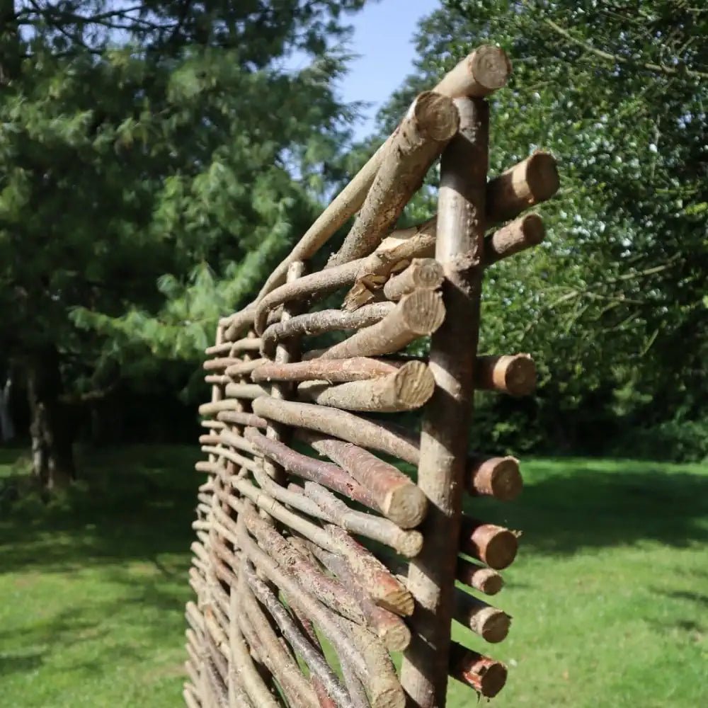Natural hazel hurdle panels providing a rustic and eco-friendly fencing solution.