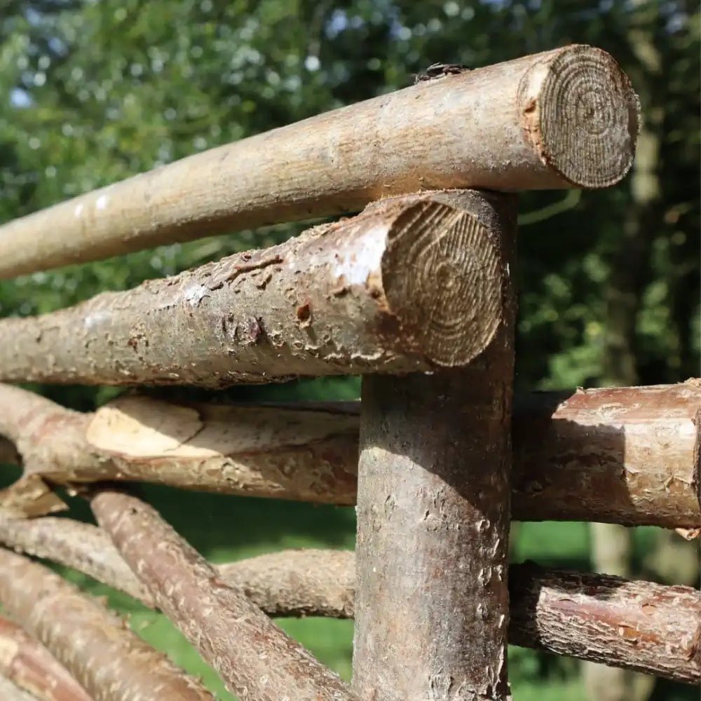 Authentic hazel hurdle panels enhancing the aesthetics of a traditional garden setting.