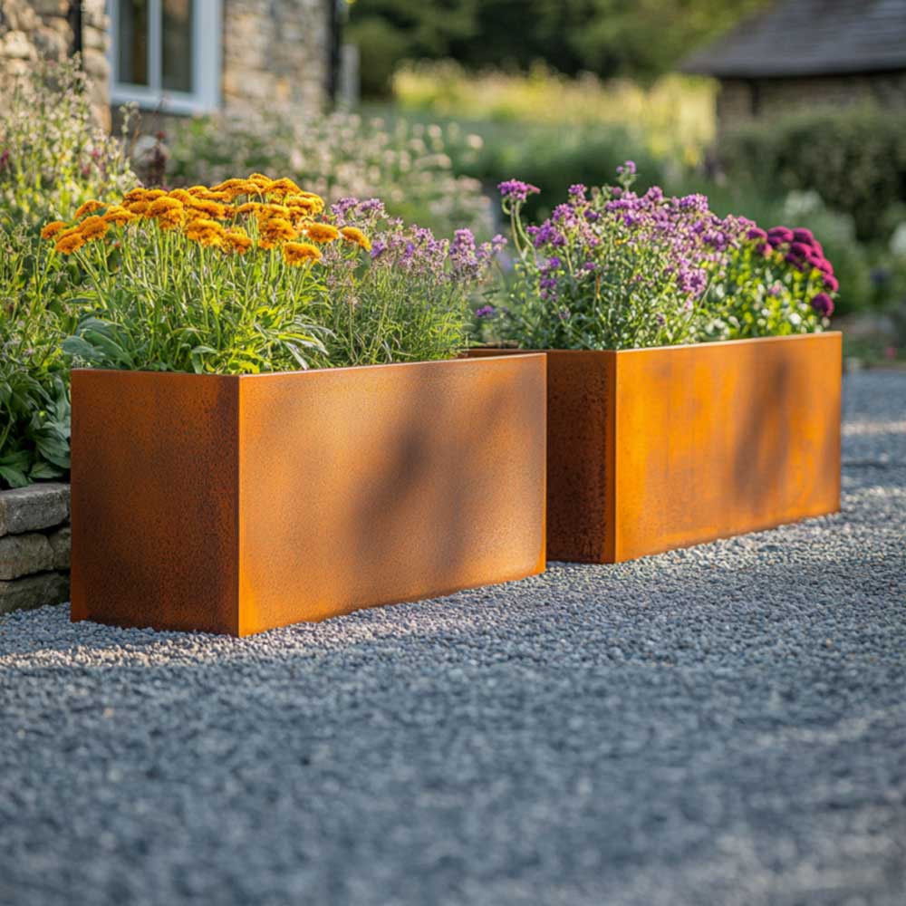 Two rust-colored metal planters with flowers in a garden setting