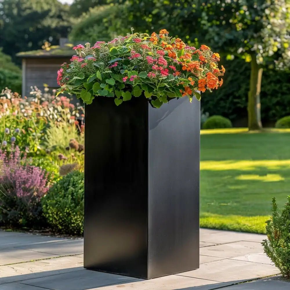 Sleek tall black planters against a white wall.