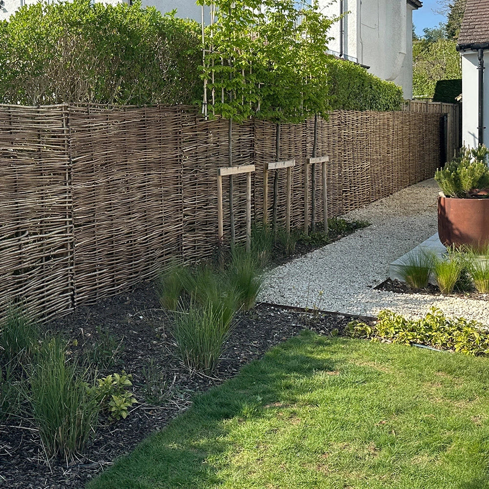 Woven hazel hurdles forming a soft boundary between the park and the neighbouring lane.