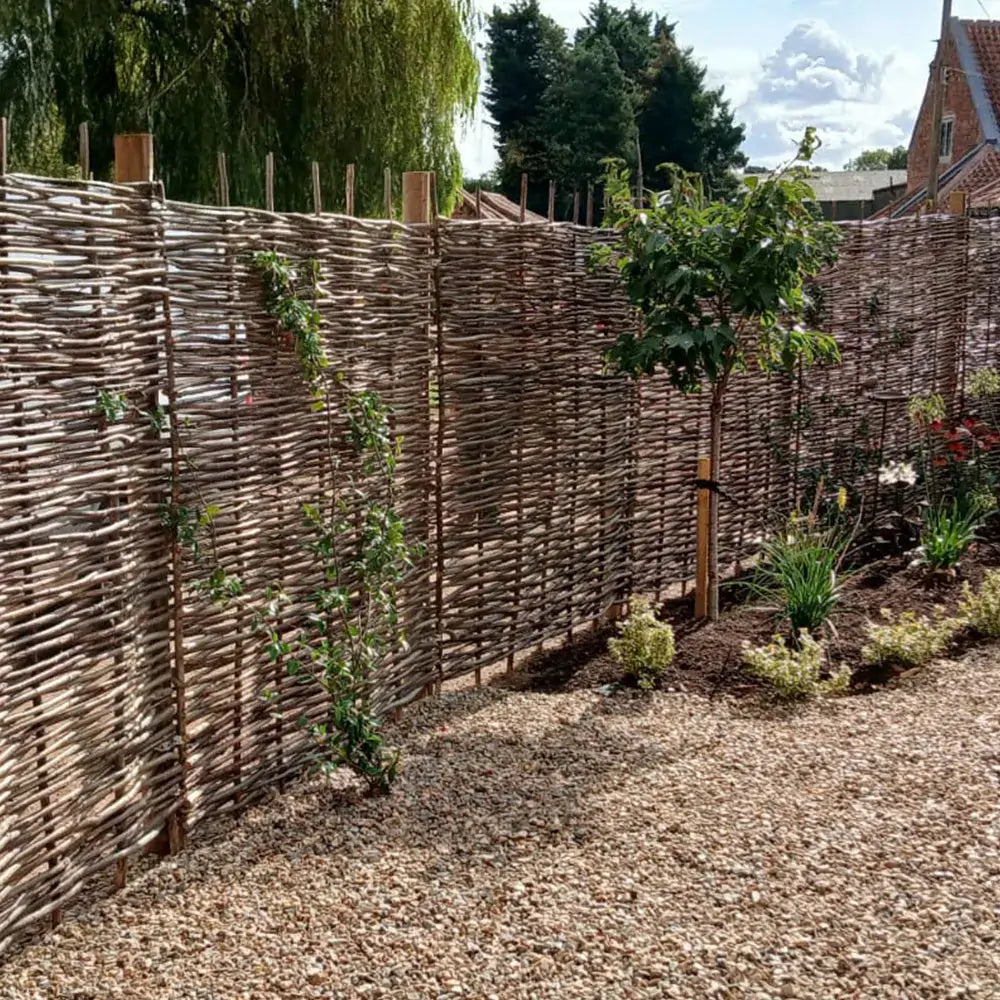 Woven hazel hurdles forming a soft boundary between the park and the neighbouring lane.