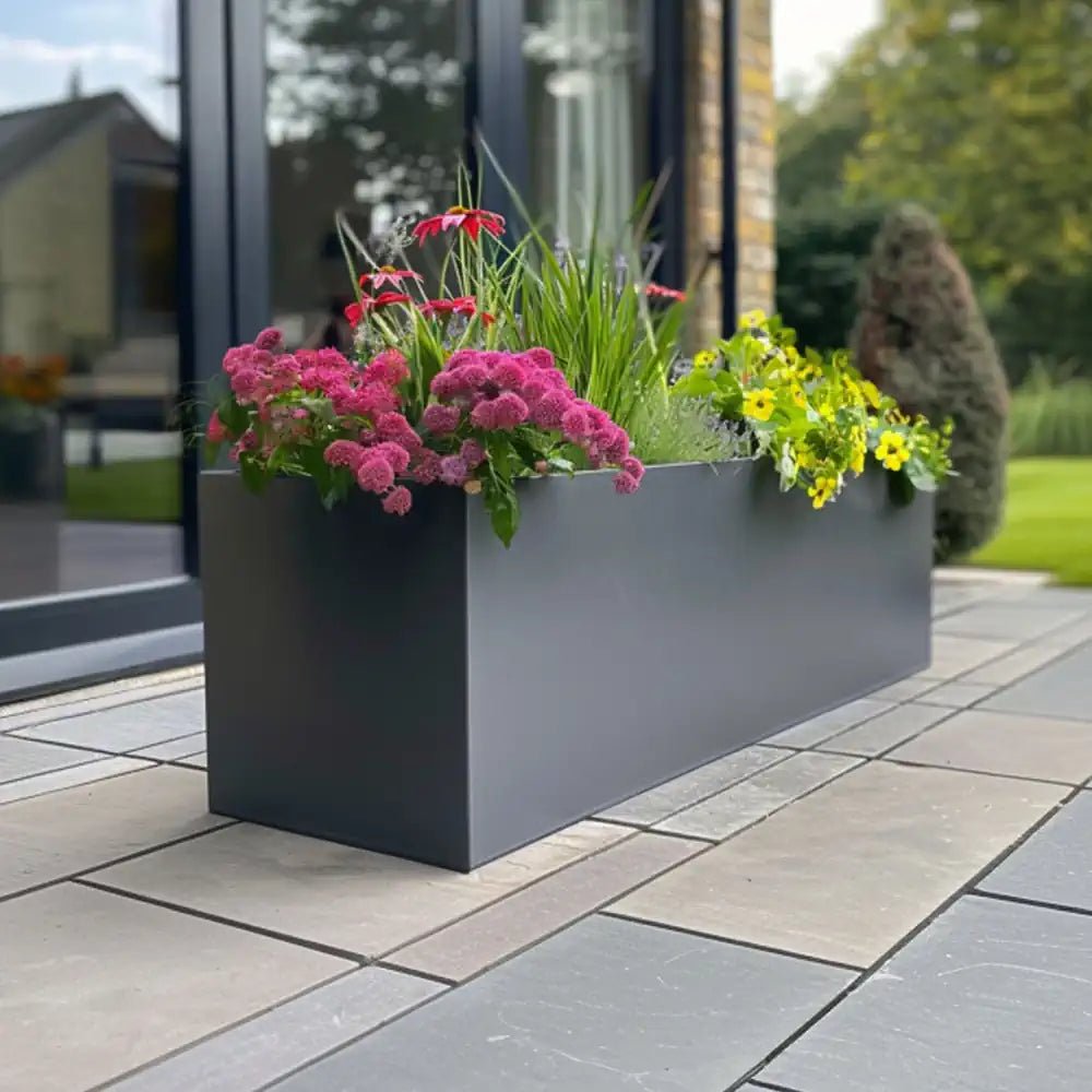 Grey planter pot filled with vibrant blooms, brightening up a balcony.