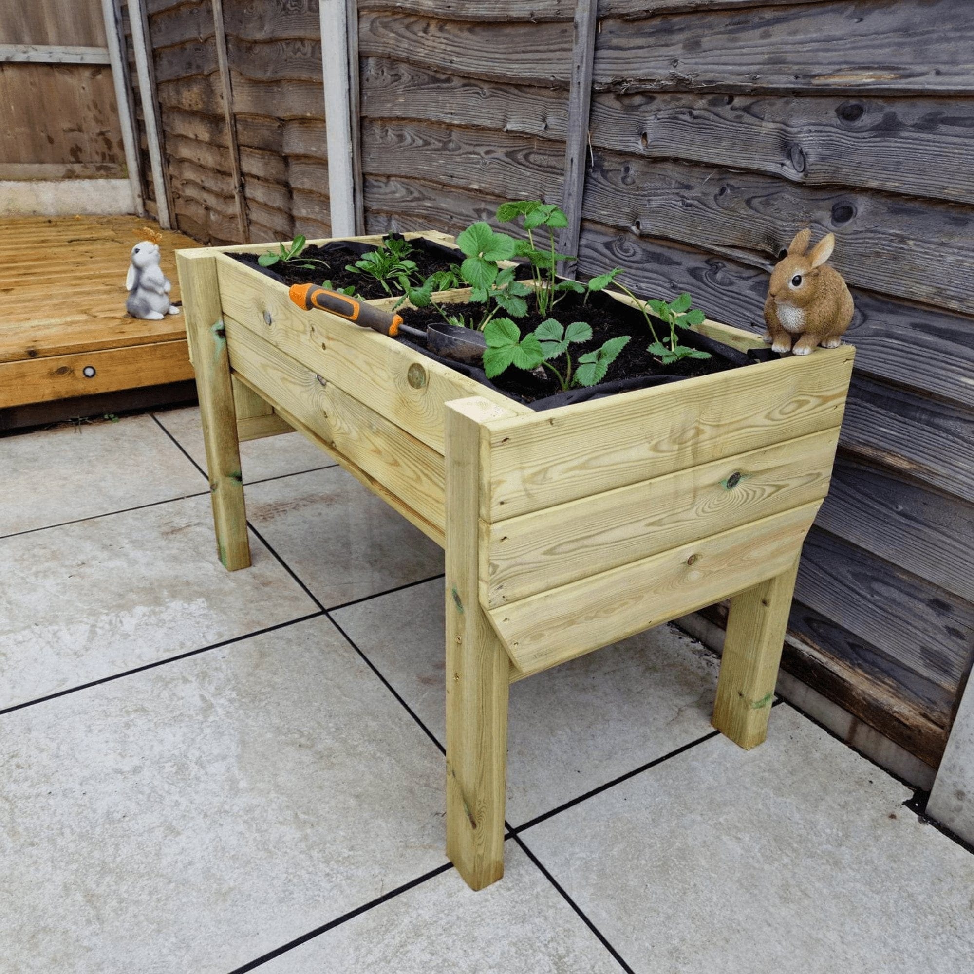 A Veg Trug with a variety of flourishing plants, adding color to a garden.