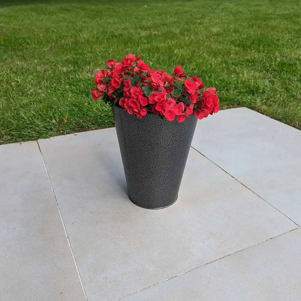 A set of zinc plant pots arranged on a patio