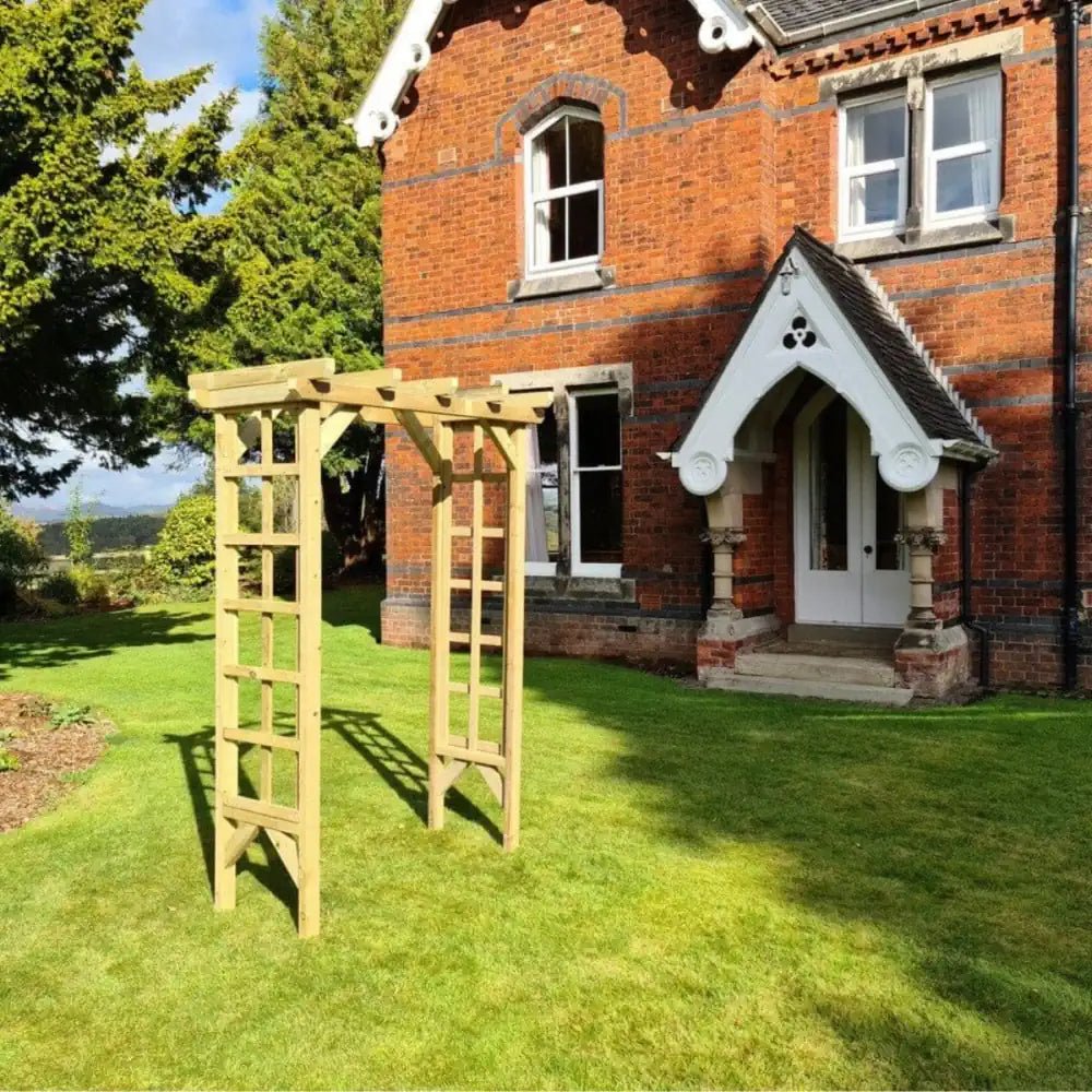 A charming wooden garden arch frames the lush greenery.