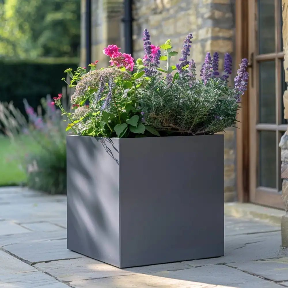 A collection of sleek grey planters arranged neatly on a patio.