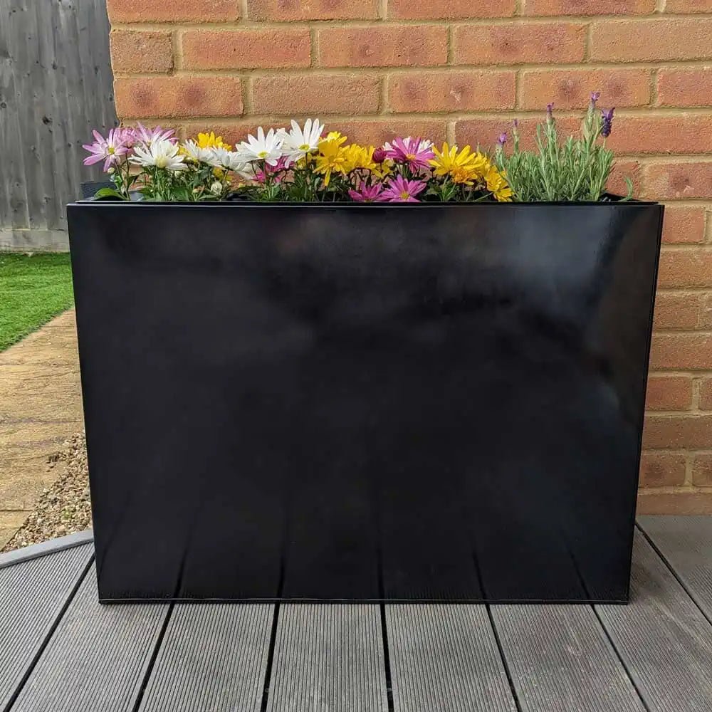 Standing tall, a striking tall black planter adds elegance to the patio.