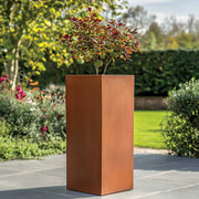 Copper planter with a small tree in a garden setting