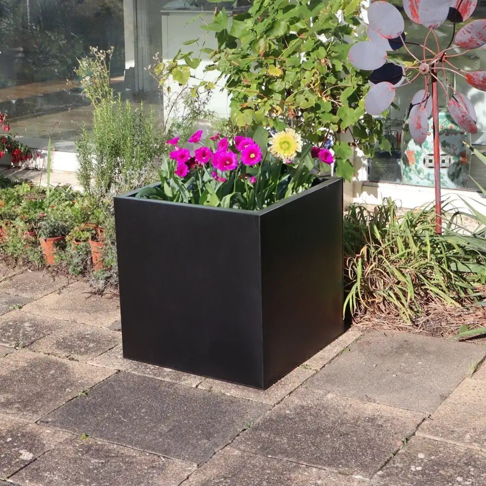 Define your outdoor oasis with the grandeur of large black planters.
