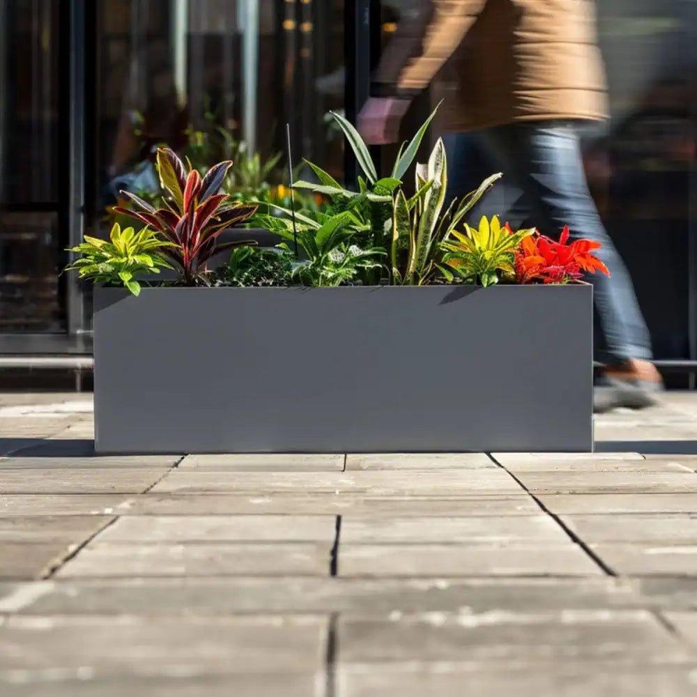 Grey plant pots arranged neatly along a walkway, adding visual interest.