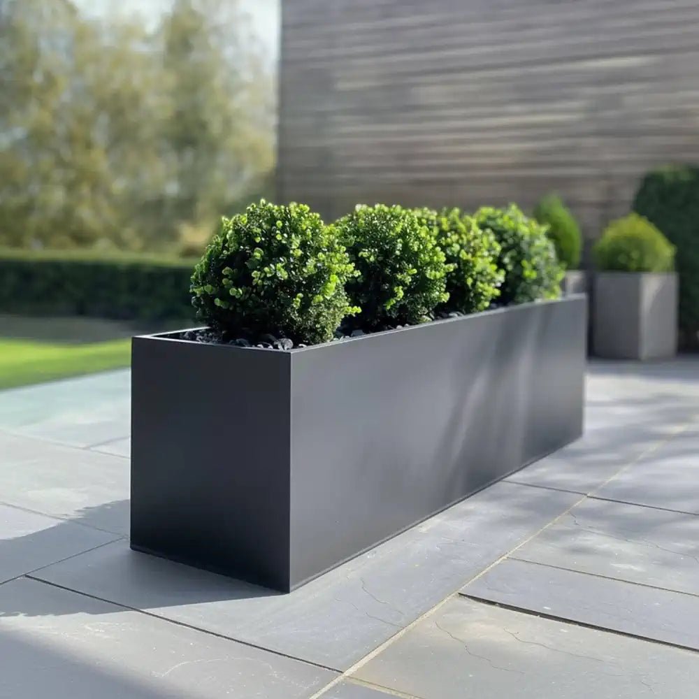 Group of grey plant pots creating a cohesive look in outdoor decor.