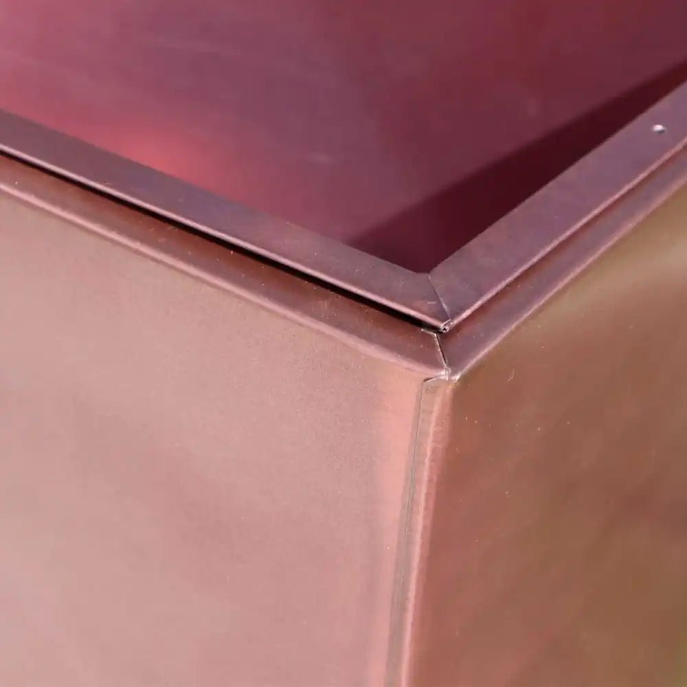 Vertical rose gold planter with a long and narrow design, perfect for displaying small plants on a window sill.