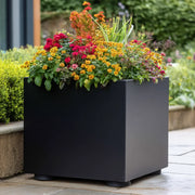 Black planter with colourful flowers in a garden setting with rubber feet for planters