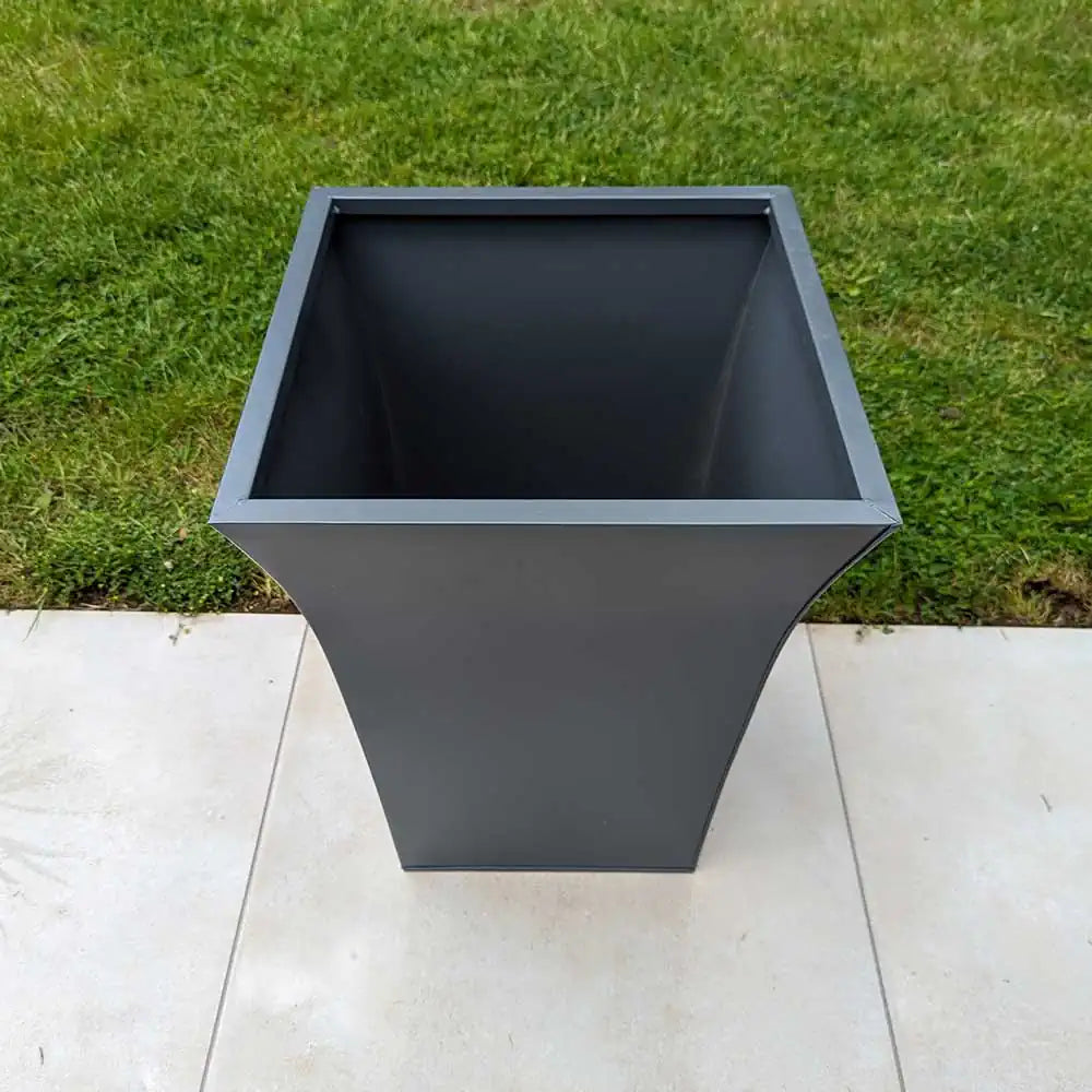 Custom weathered zinc planters zoning the dining and lounge areas of the terrace.