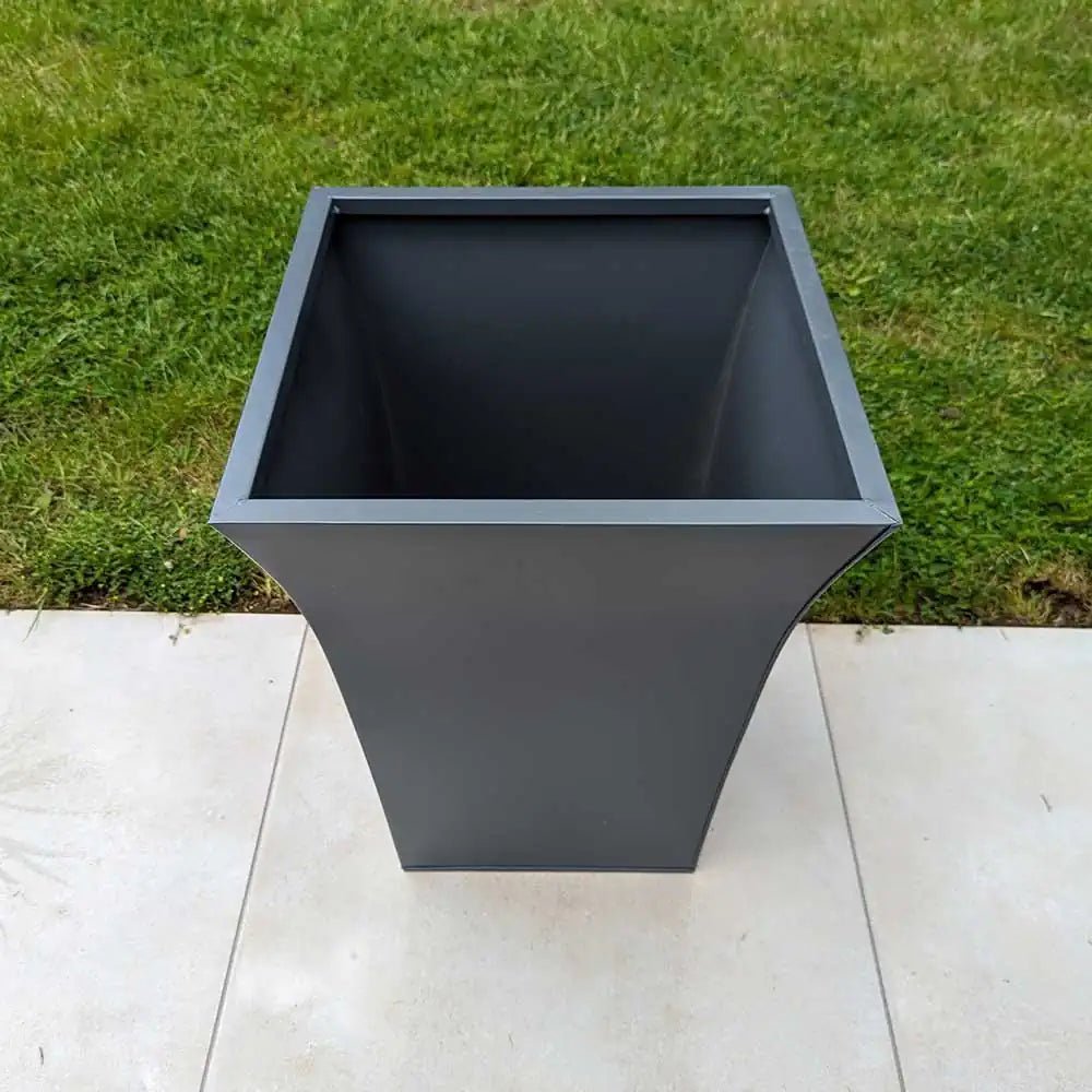 Custom weathered zinc planters zoning the dining and lounge areas of the terrace.