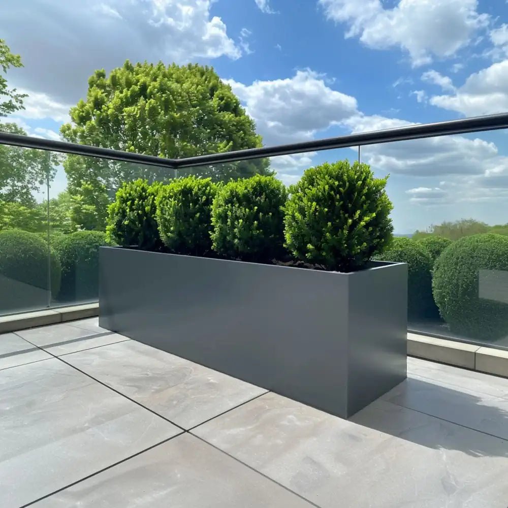 A sleek grey planter pot adding modern elegance to a garden.