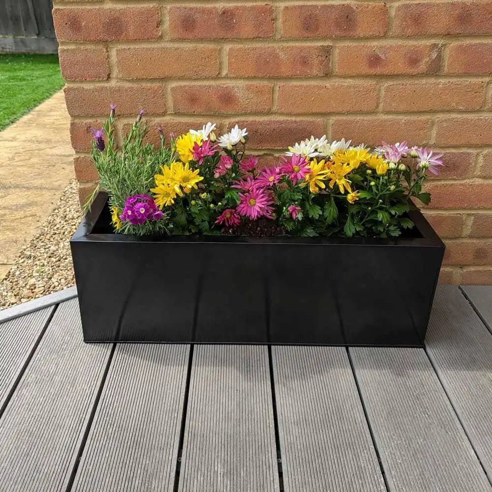 A lineup of long planters, creating a natural border along the patio.